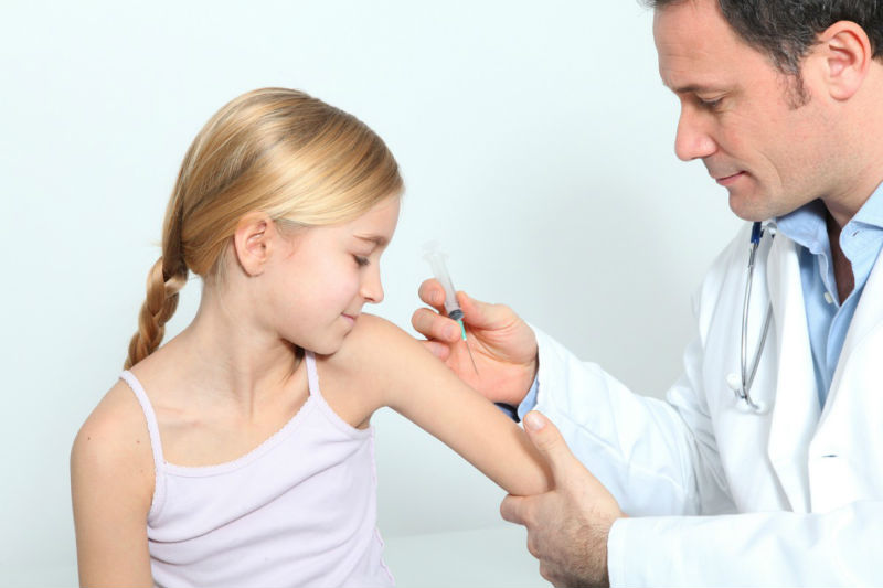 Девочке доктор делает прививку