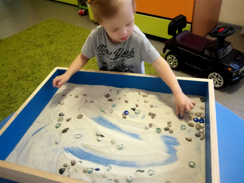 Мальчик играет с песком