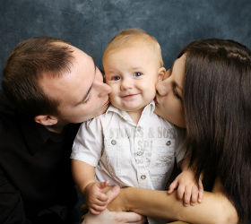 семья целует ребенка